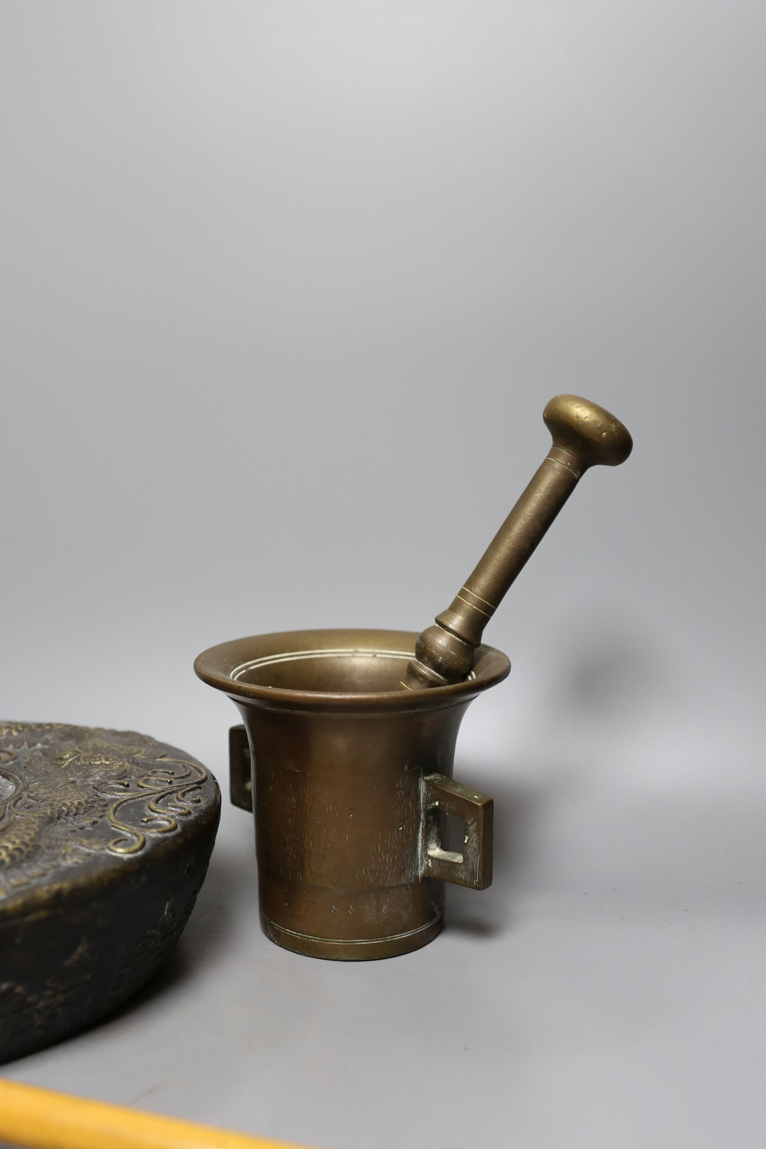 Two pestles and mortars and a Chinese gong with beater, gong 21 cms wide.